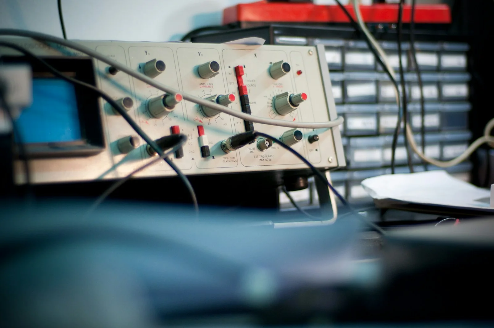 Osciloscopio y cables de prueba sobre un banco de trabajo. Fotografía referencial.